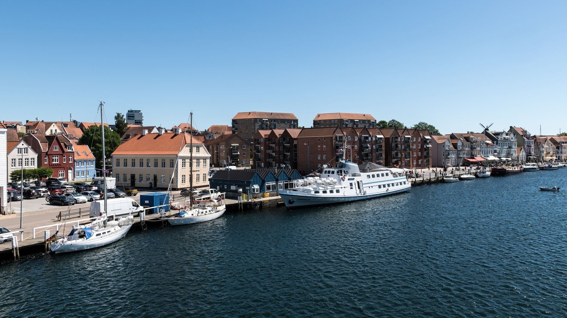 Sønderborgs havnefront med både, historiske huse og moderne boligbyggeri